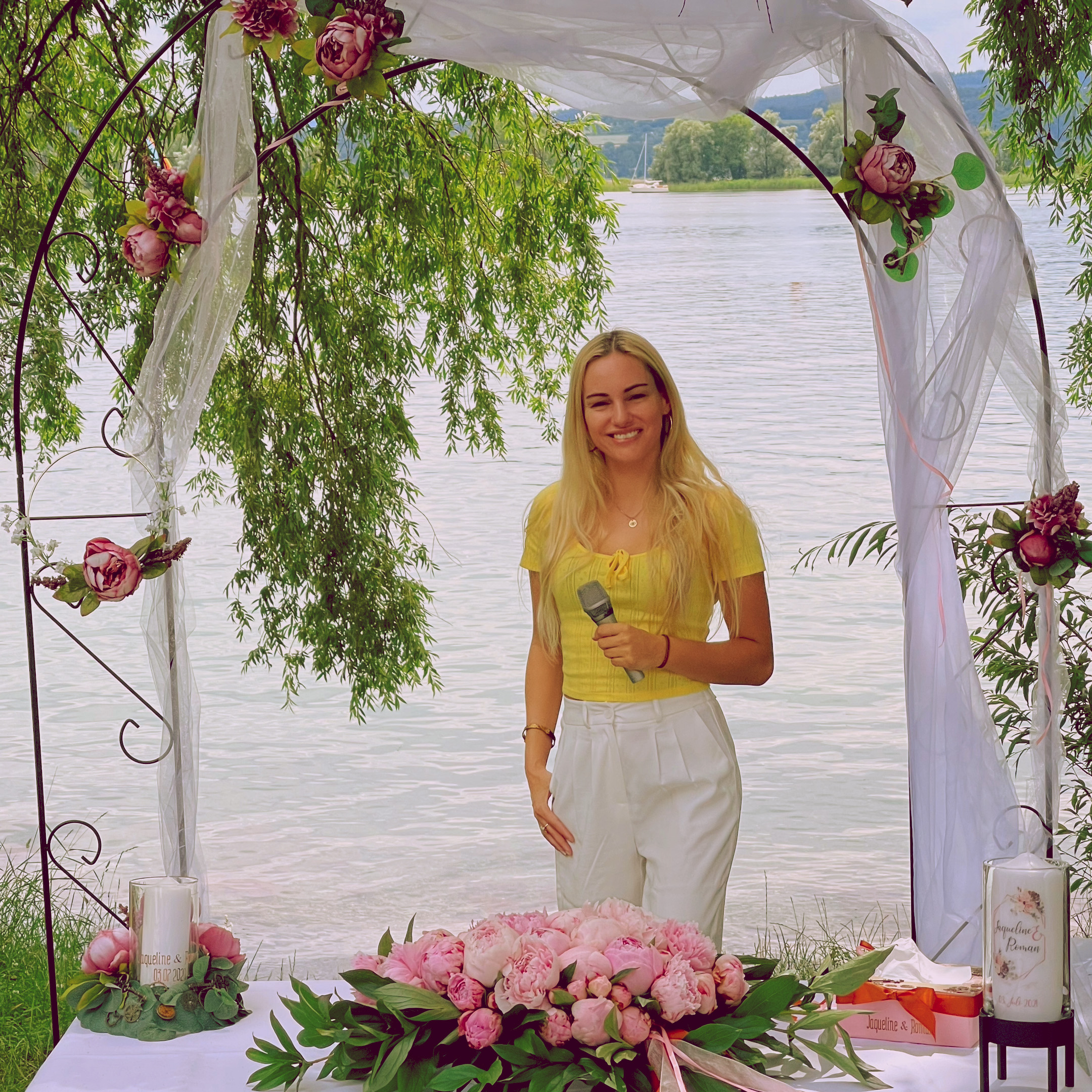 Hochzeitssängerin Sina Anastasia unter einem Blumenbogen